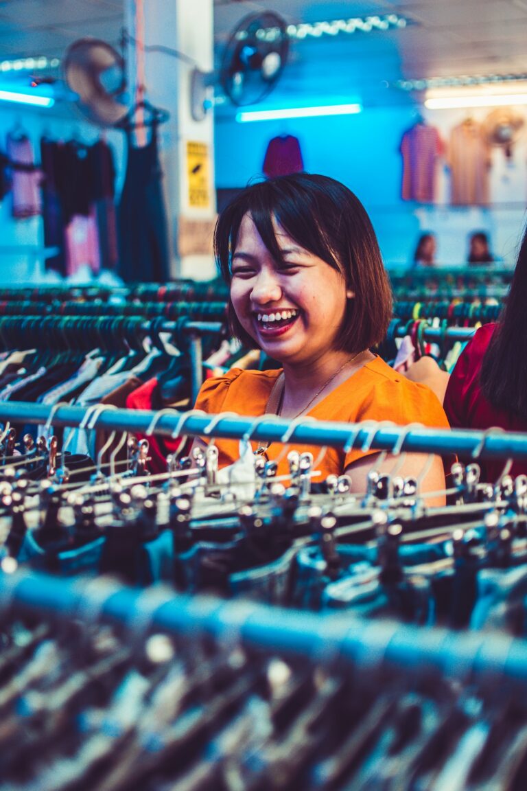 Emprendedora sonriente junto a su ropa