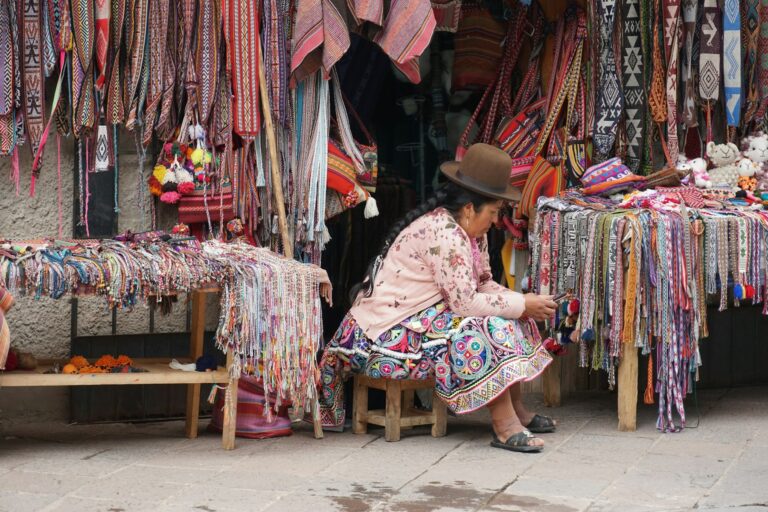 Mujer en su puesto de textiles en un mercado andino