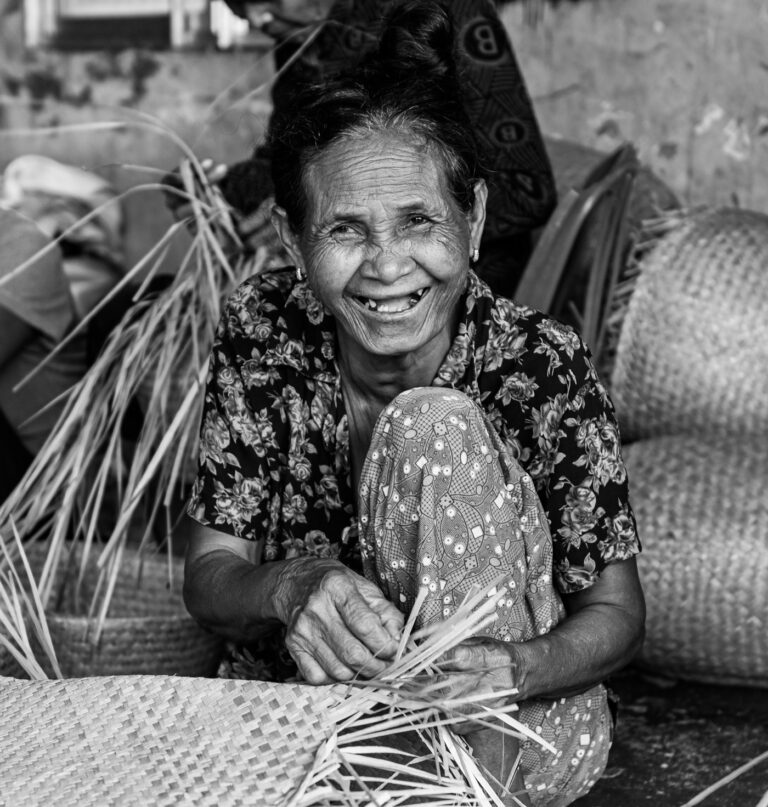 Artesana sonriente tejiendo canastas